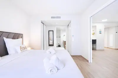 a white bedroom with a large bed with white pillows at Sud Croisette - Proche Palais des Festivals in Cannes