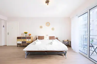 a white bedroom with a bed and a large window at Sud Croisette - Proche Palais des Festivals in Cannes