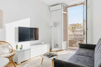 a living room with a couch and a tv at Le Rosy - Apartment in Central Cannes Balcony in Cannes