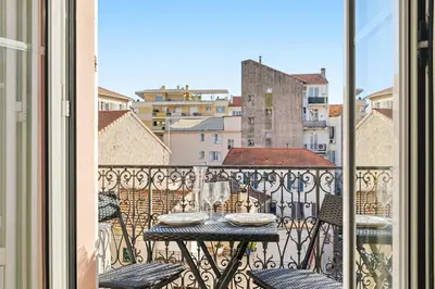 a table on a balcony with a view of a city at Le Rosy - Apartment in Central Cannes Balcony in Cannes