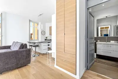 a living room with a couch and a kitchen at Le Rosy - Apartment in Central Cannes Balcony in Cannes
