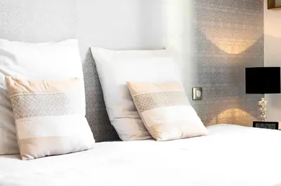a white bed with two pillows on top of it at Le Rosy - Apartment in Central Cannes Balcony in Cannes