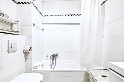a white bathroom with a tub and a toilet at Jardin Suquet - Appartement panoramique Grande terrasse vue sur mer & Palais in Cannes