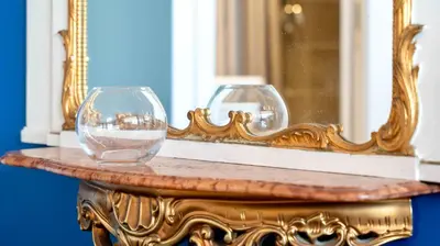 two wine glasses on a table in front of a mirror at Jardin Suquet - Appartement panoramique Grande terrasse vue sur mer & Palais in Cannes