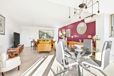a dining room and living room with a glass table at Jardin Suquet - Appartement panoramique Grande terrasse vue sur mer & Palais in Cannes
