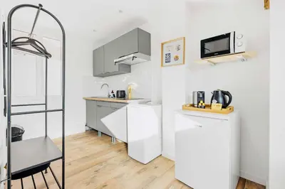 a small kitchen with a refrigerator and a microwave at Suite Azur - Appartement en plein centre de Cannes - Climatisation - Wifi - Proche du Palais des Festivals et des Commerces in Cannes