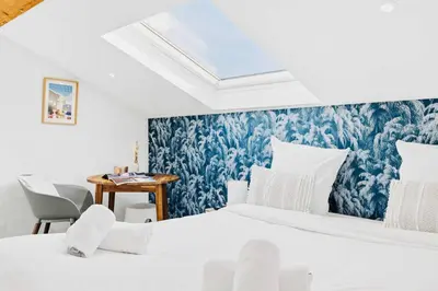 a bedroom with a bed and a blue and white wallpaper at Suite Azur - Appartement en plein centre de Cannes - Climatisation - Wifi - Proche du Palais des Festivals et des Commerces in Cannes