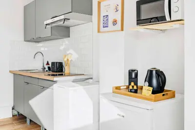 a white kitchen with a sink and a microwave at Suite Azur - Appartement en plein centre de Cannes - Climatisation - Wifi - Proche du Palais des Festivals et des Commerces in Cannes