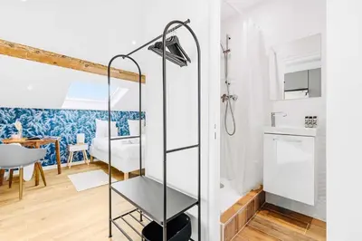 a bathroom with a glass shower stall and a dining room at Suite Azur - Appartement en plein centre de Cannes - Climatisation - Wifi - Proche du Palais des Festivals et des Commerces in Cannes