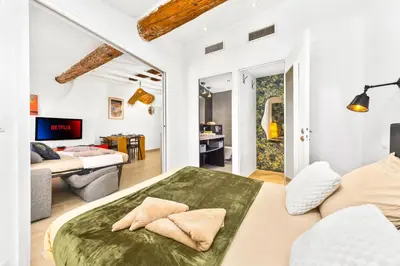 a bedroom with a bed and a living room at Coeur de ville - Charmant appartement rénové - FS in Cannes