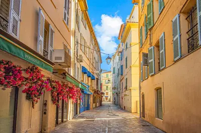 an alley in an old town with flowers hanging from buildings at Coeur de ville - Charmant appartement rénové - FS in Cannes