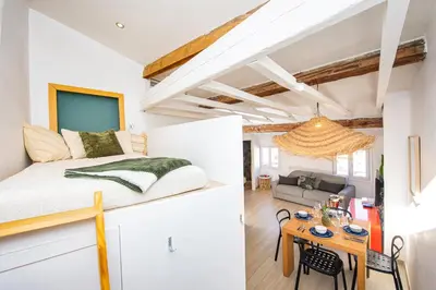 a bedroom and living room with a bed and a table at Coeur de ville - Charmant appartement rénové - FS in Cannes