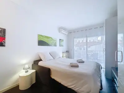 a white bedroom with a large bed and a window at Le Narval - Studio - Croisette - Proche Palais in Cannes