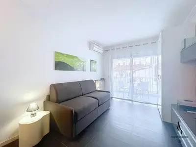 a living room with a couch and a large window at Le Narval - Studio - Croisette - Proche Palais in Cannes