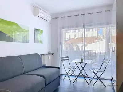 a living room with a couch and a table with chairs at Le Narval - Studio - Croisette - Proche Palais in Cannes