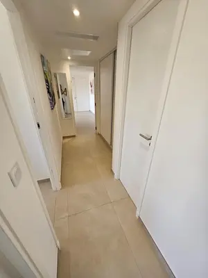a hallway with white doors and a tile floor at 3 pièces lumineux à Cannes in Cannes