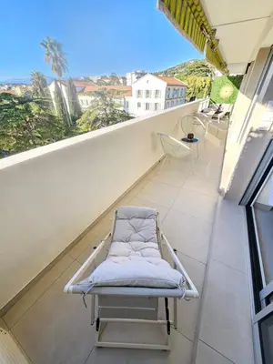a balcony with a white chair on at 3 pièces lumineux à Cannes in Cannes