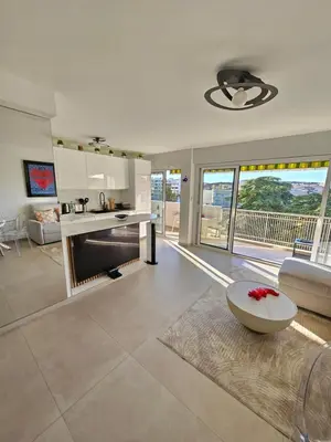 a kitchen and living room with a couch and a table at 3 pièces lumineux à Cannes in Cannes