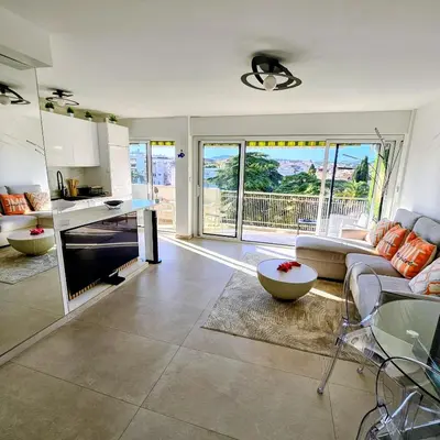 a kitchen and living room with a couch and a table at 3 pièces lumineux à Cannes in Cannes