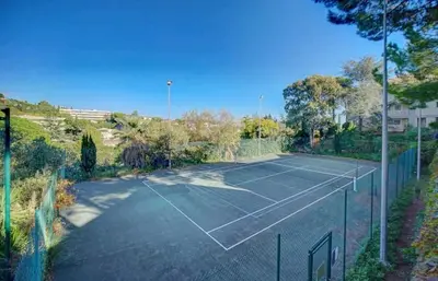 a tennis court with a net on top of it at Cannes, garden level, pool, nearby beaches in Cannes