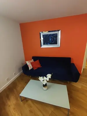 a living room with a blue couch and a table at Cannes, garden level, pool, nearby beaches in Cannes