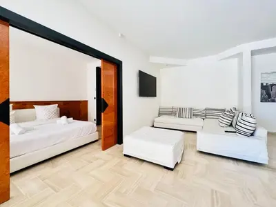 a room with two beds and two couches at Le Gray - Terrasse Centre Cannes Croisette & Palais in Cannes