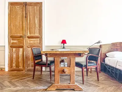 a room with a table and chairs and a bed at L'olivine - Paisible Loft avec terrasse Cannes in Cannes