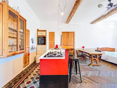 a kitchen with a red counter top in a room at L'olivine - Paisible Loft avec terrasse Cannes in Cannes