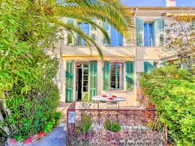a table in front of a house with trees at L'olivine - Paisible Loft avec terrasse Cannes in Cannes