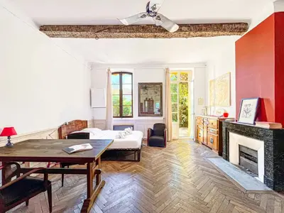 a living room with a table and a fireplace at L'olivine - Paisible Loft avec terrasse Cannes in Cannes
