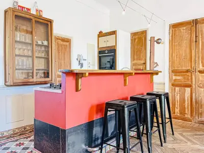 a kitchen with a bar with stools around it at L'olivine - Paisible Loft avec terrasse Cannes in Cannes