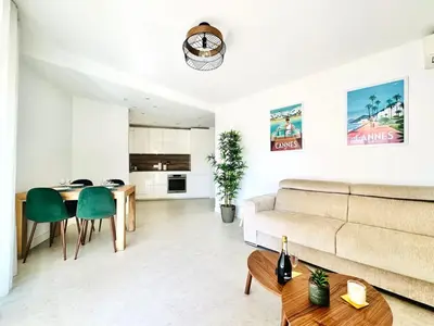 a living room with a couch and a table at Le Stanislas - Appartement 2 Chambres Terrasse in Cannes