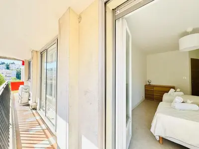 a bedroom with a bed and a balcony at Le Stanislas - Appartement 2 Chambres Terrasse in Cannes