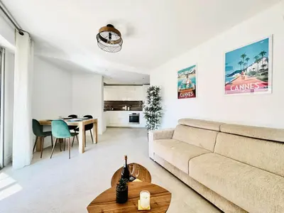 a living room with a couch and a table at Le Stanislas - Appartement 2 Chambres Terrasse in Cannes