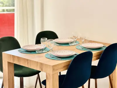 a wooden table with chairs and plates and glasses at Le Stanislas - Appartement 2 Chambres Terrasse in Cannes