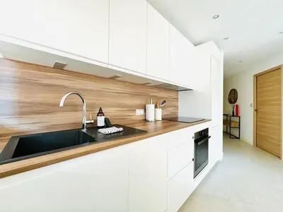 a kitchen with white cabinets and a sink at Le Stanislas - Appartement 2 Chambres Terrasse in Cannes