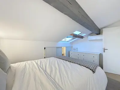 a bedroom with a large white bed with a window at 31m2 - appartement en plein centre-ville in Cannes
