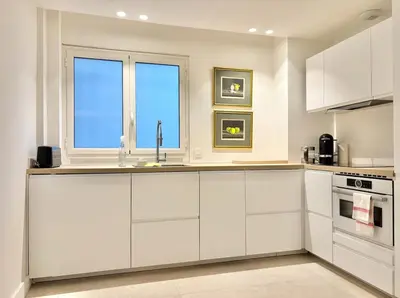 a kitchen with white cabinets and a window at Cannes - 2 bedrooms & 2 bathrooms apartment - 24P1 in Cannes
