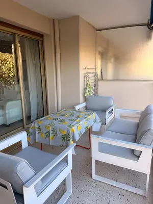 a room with couches and a table and chairs at BELLE PLAGE, deux chambres proche mer in Cannes