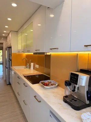 a kitchen with white cabinets and a counter top at BELLE PLAGE, deux chambres proche mer in Cannes