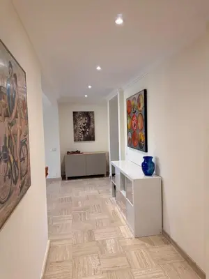 a hallway with paintings on the wall and a table at BELLE PLAGE, deux chambres proche mer in Cannes