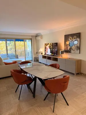 a large living room with a table and chairs at BELLE PLAGE, deux chambres proche mer in Cannes