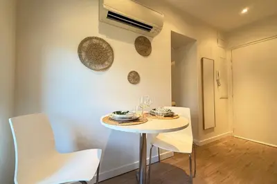 a small white table and chairs in a room at Central studio with real bed near the Palais in Cannes