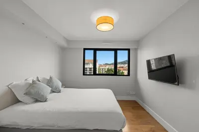 a white bedroom with a bed and a window at Stunning 3BR apartment Carlton Riviera Croisette in Cannes