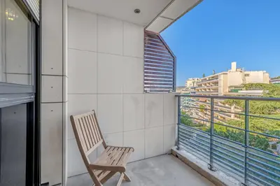 a chair on a balcony with a view of a city at Sublime 2BR apartment Carlton Riviera Croisette in Cannes