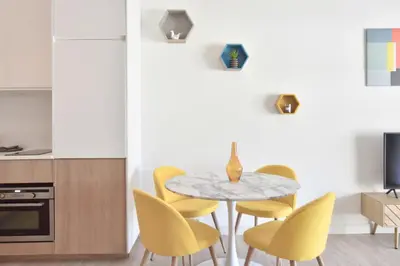 a dining room with a table and yellow chairs at 1-Br with Terrace Carré dOr Walking Distance to the Beaches in Cannes