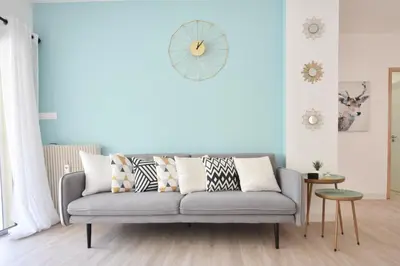 a living room with a gray couch with pillows at 1-Br with Terrace Carré dOr Walking Distance to the Beaches in Cannes
