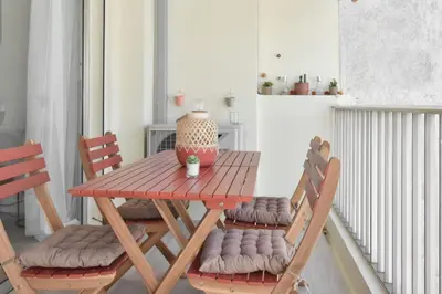 a table and chairs with a vase on a balcony at 1-Br with Terrace Carré dOr Walking Distance to the Beaches in Cannes