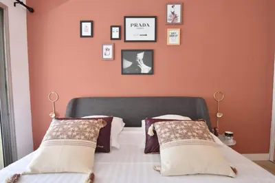 a bedroom with orange walls and a bed with pillows at 1-Br with Terrace Carré dOr Walking Distance to the Beaches in Cannes