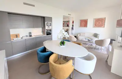 a kitchen and living room with a white table and chairs at Ref DUNES3 by Palmes d Or Properties in Cannes